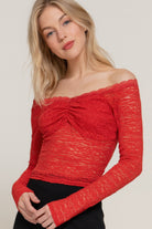 Close-up of red lace off-shoulder top with ruched bust detail.