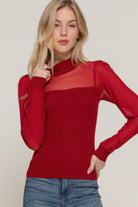 Woman wearing a red soft ribbed knit sweater top with a wide neckline and relaxed fit, styled with blue jeans – minimal and chic everyday look-AVAH