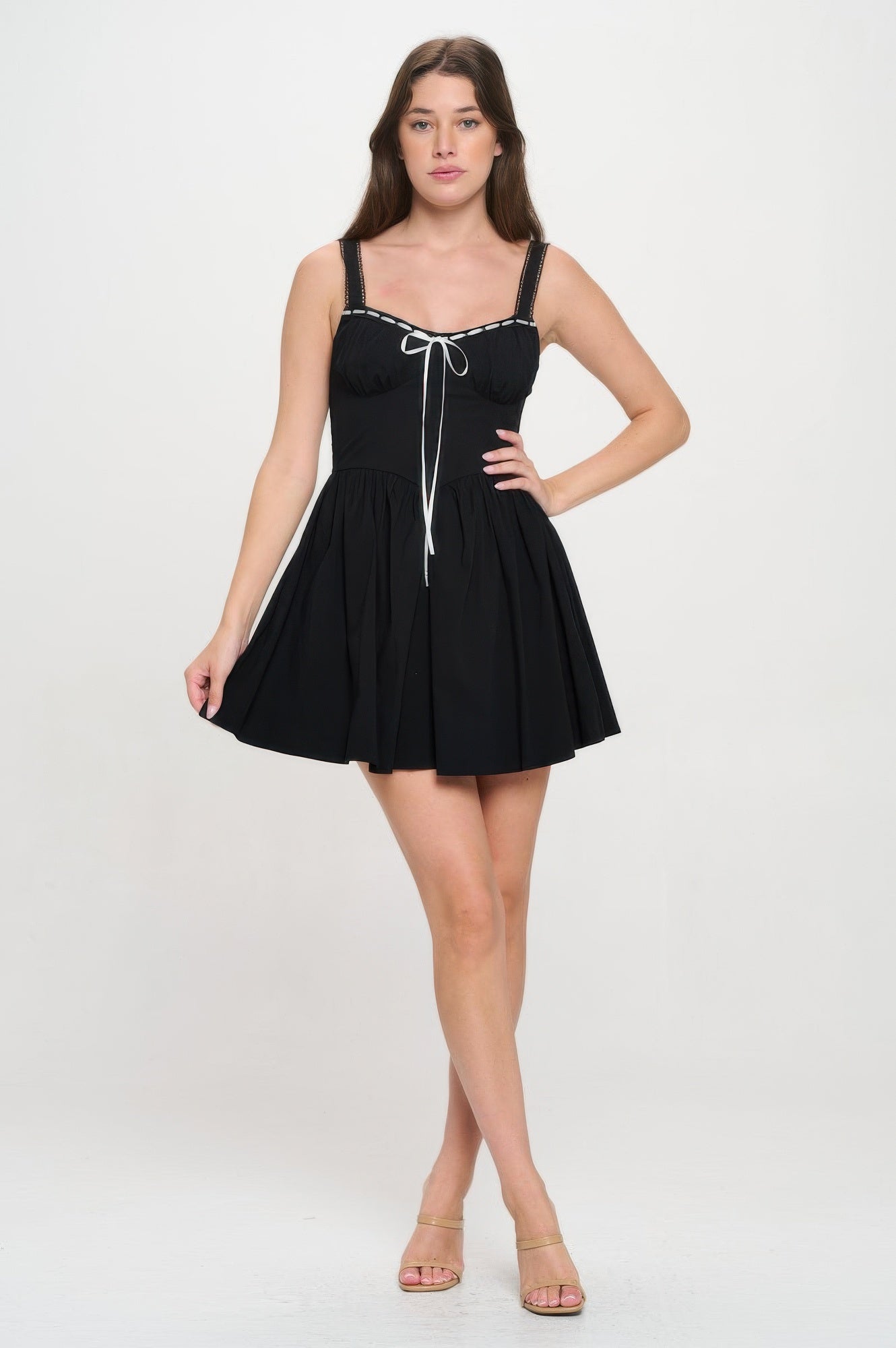 Full front view of black contrast-trim mini dress with white bow and flared skirt