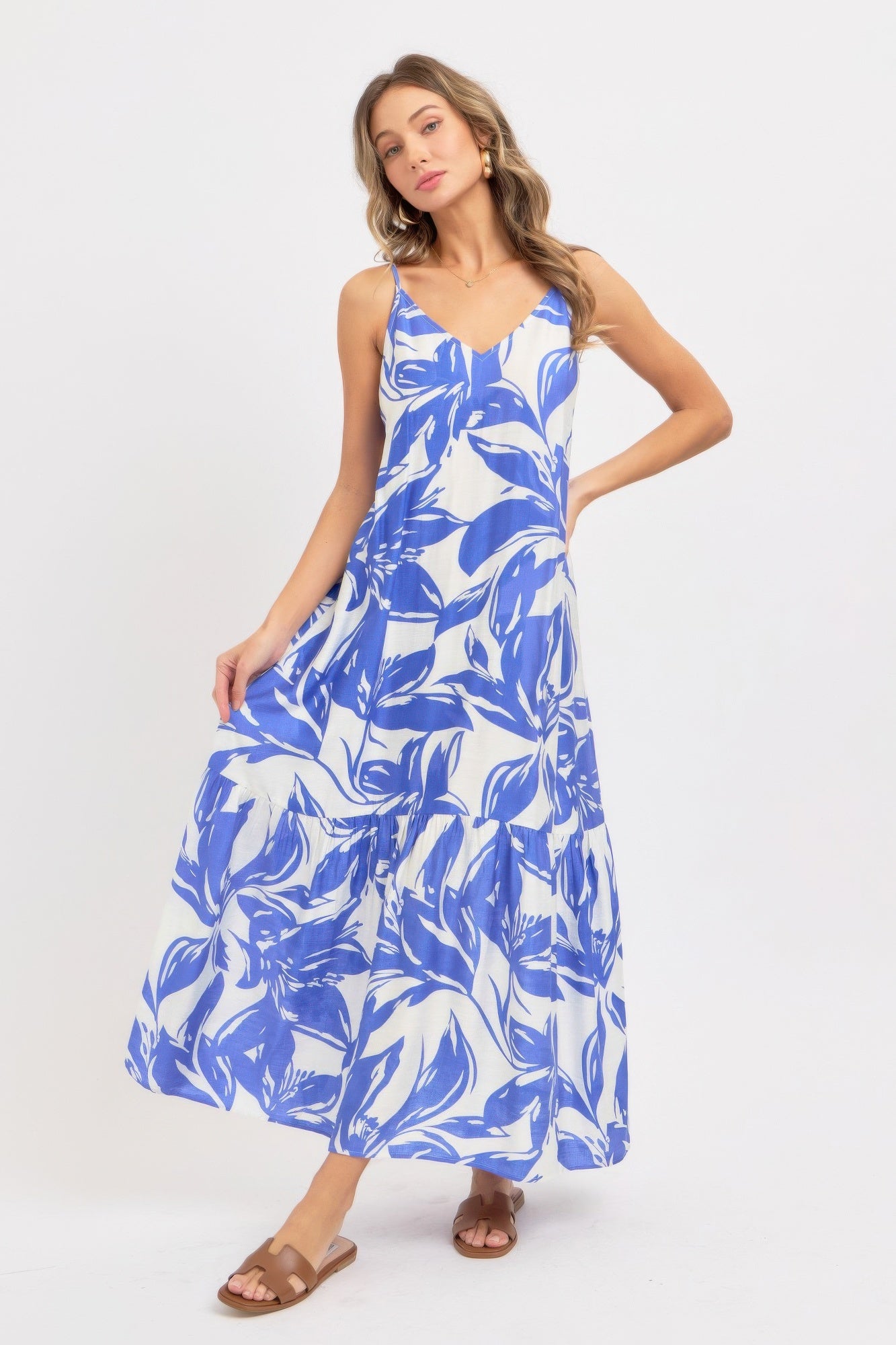 Model wearing a blue and white floral maxi dress on a white background