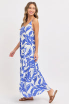 Model wearing a blue floral tiered maxi dress walking side view
