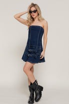 Model wearing strapless denim mini dress with black boots
