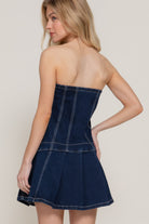 Back view of strapless dark wash denim dress with flared skirt
