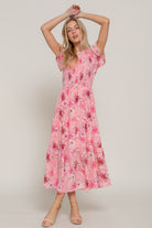 Front view of pink floral maxi dress, model raising arms to show flowy skirt-AVAH