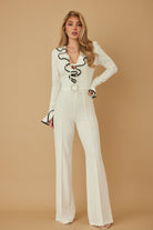 Ivory wide-leg jumpsuit with ruffle neckline and contrast trim, front view
