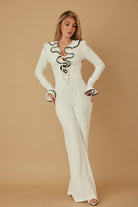 Ivory ruffle front jumpsuit with deep V neckline and waist detail
