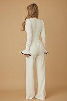 Rear angle of ivory jumpsuit showing long sleeve and tailored fit