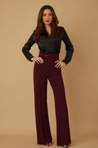 Woman wearing burgundy high waist wide leg pants with matching belt
