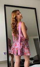 Back view of the floral sequin dress with long satin tie straps hanging down.