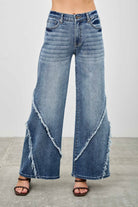 Wide leg blue denim jeans front view with distressed diagonal seam detailing
