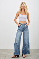 Wide leg jeans worn with white crop top showing high rise fit and relaxed silhouette
