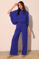 Model wearing the Quiet Luxury Royal Blue Wide Leg Jumpsuit, AVAH