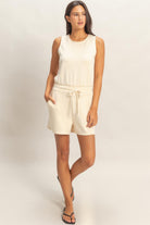 Cream sleeveless relaxed fit romper with elastic waist and drawstring tie
