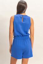 Back view of cobalt blue sleeveless romper with elastic waist and keyhole closure
