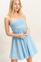 Model wearing light blue eyelet mini dress with strapless neckline
