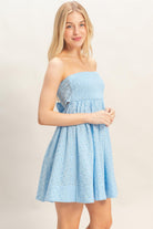 Side view of blue smocked strapless mini dress with flowy skirt
