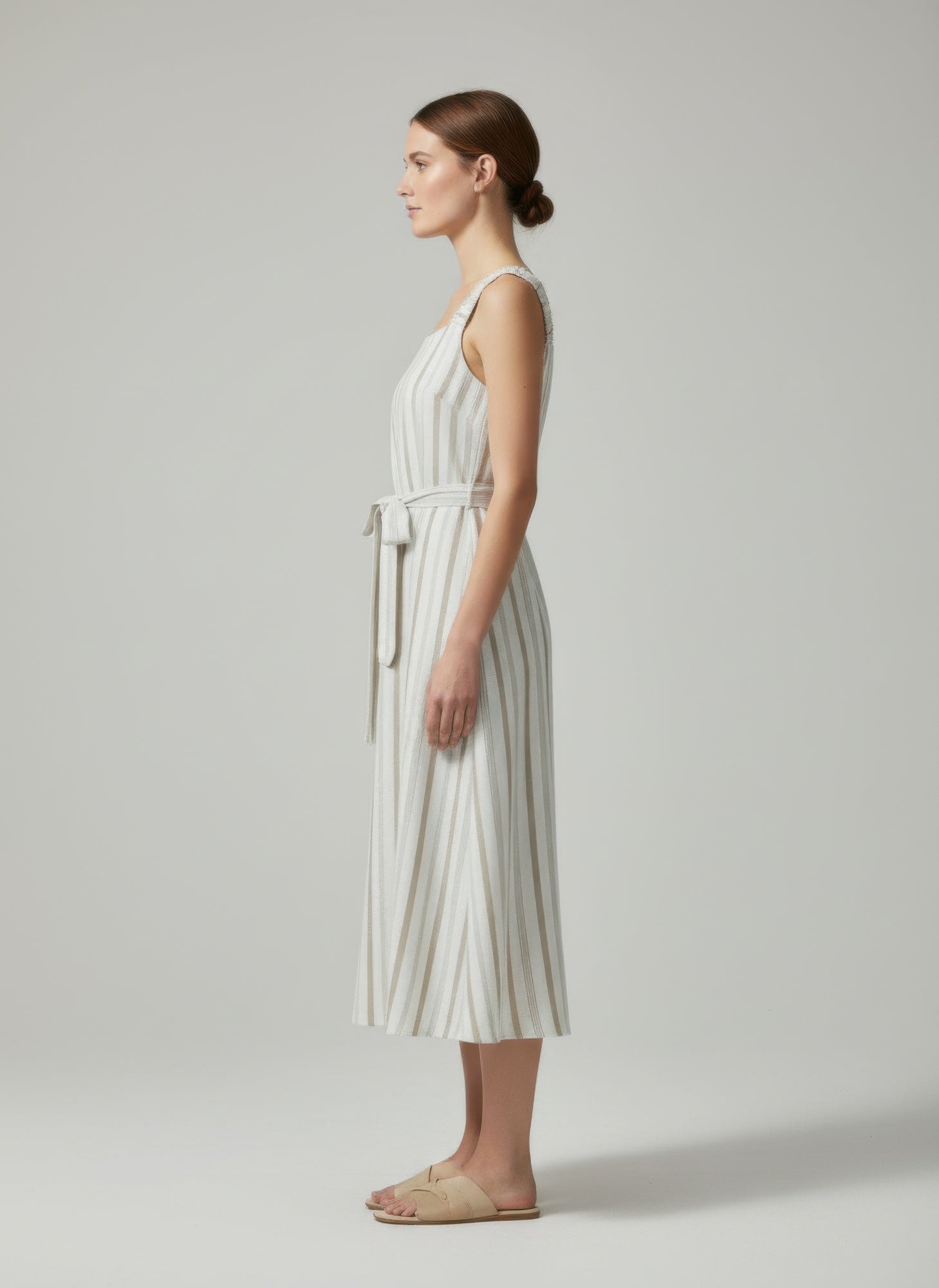 Model wearing striped cotton midi dress with minimal sandals-side view