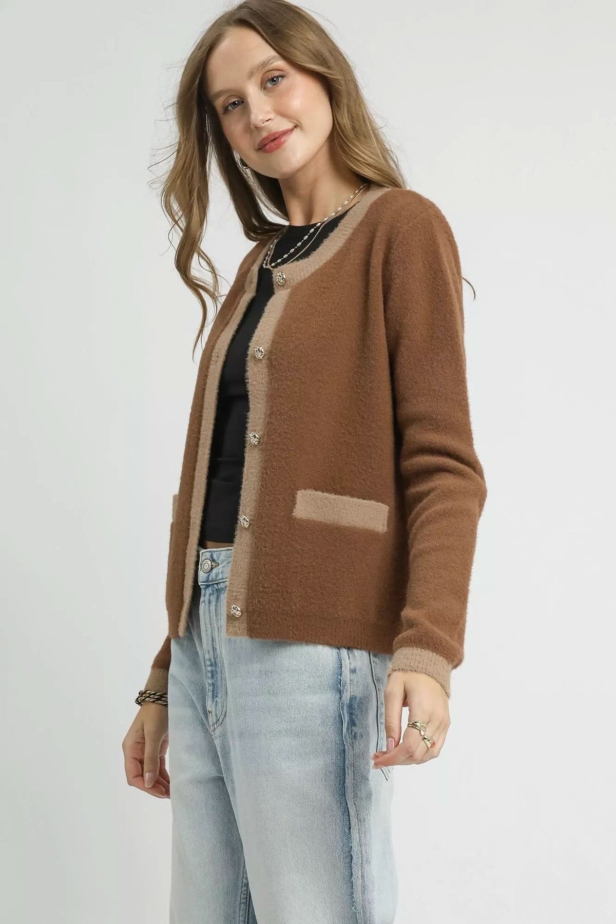 Side angled view of latte brown contrast trim cardigan showing soft fuzzy knit, round neckline and long sleeves.