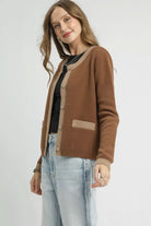 Side angled view of latte brown contrast trim cardigan showing soft fuzzy knit, round neckline and long sleeves.