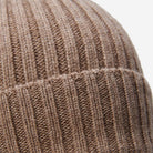Close-up of a brown knitted beanie with ribbed texture.