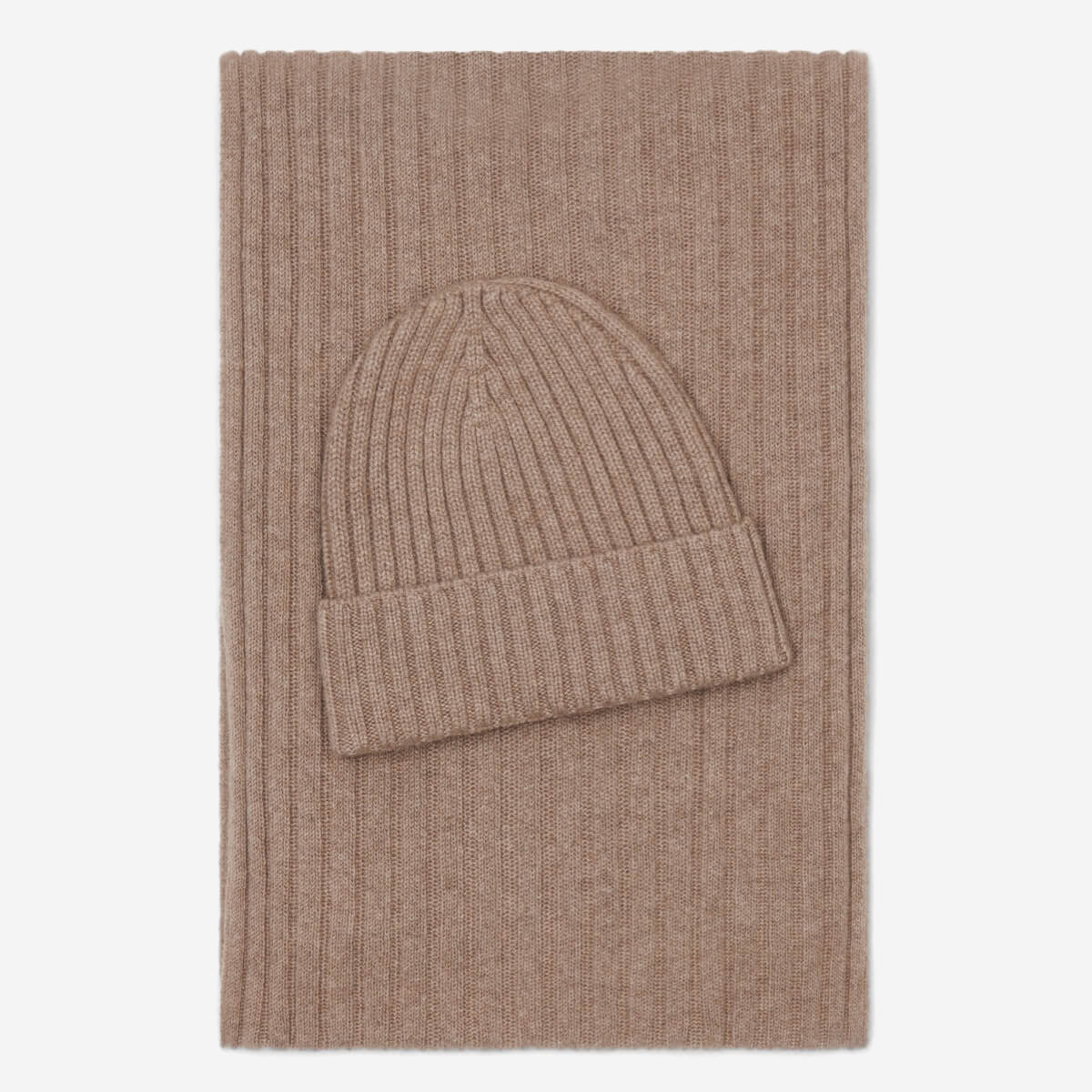 Brown knit beanie and scarf set on a light beige background