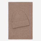 Brown knit beanie and scarf set on a light beige background