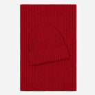 Red knit hat on a red rectangular blanket with a white background