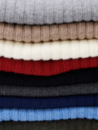 Stack of folded cashmere scarves in various colors