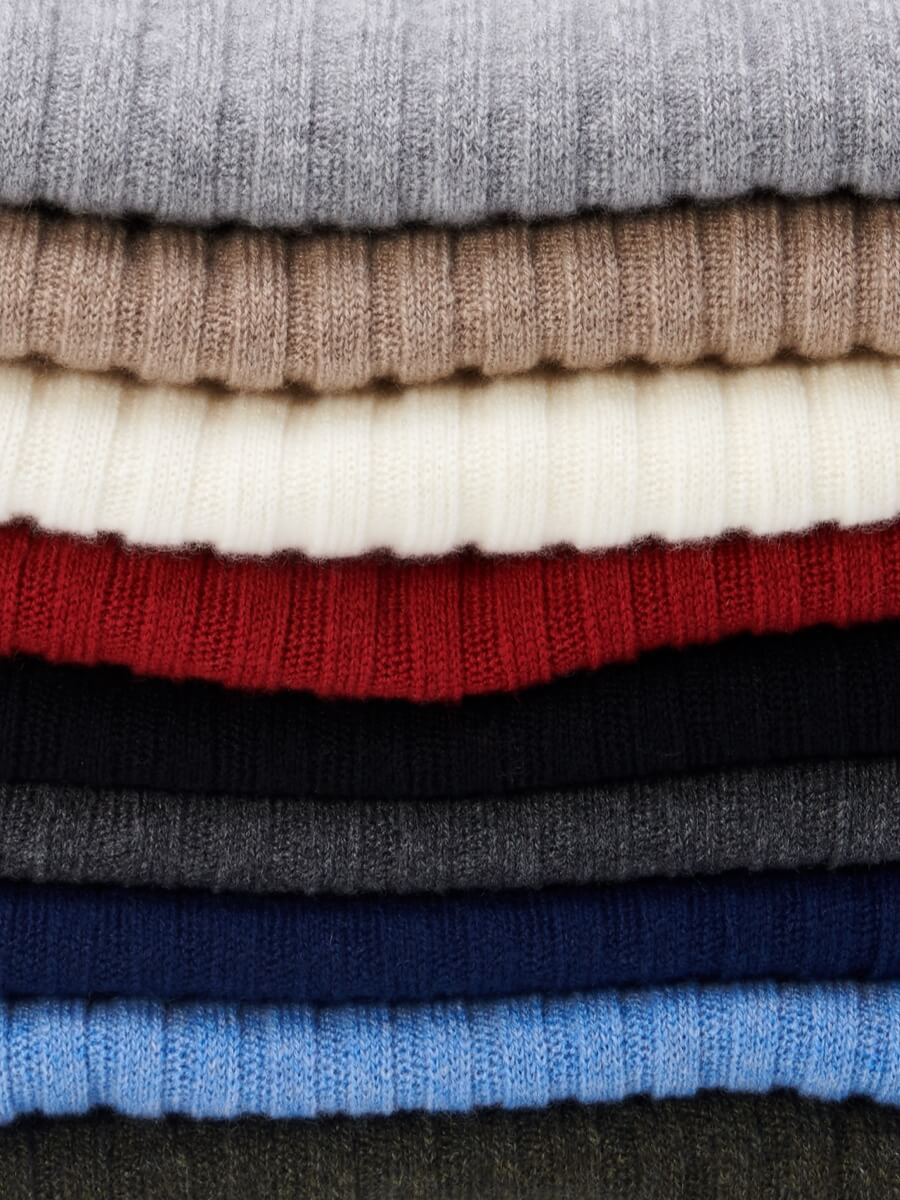 Stack of folded cashmere scarves in various colors