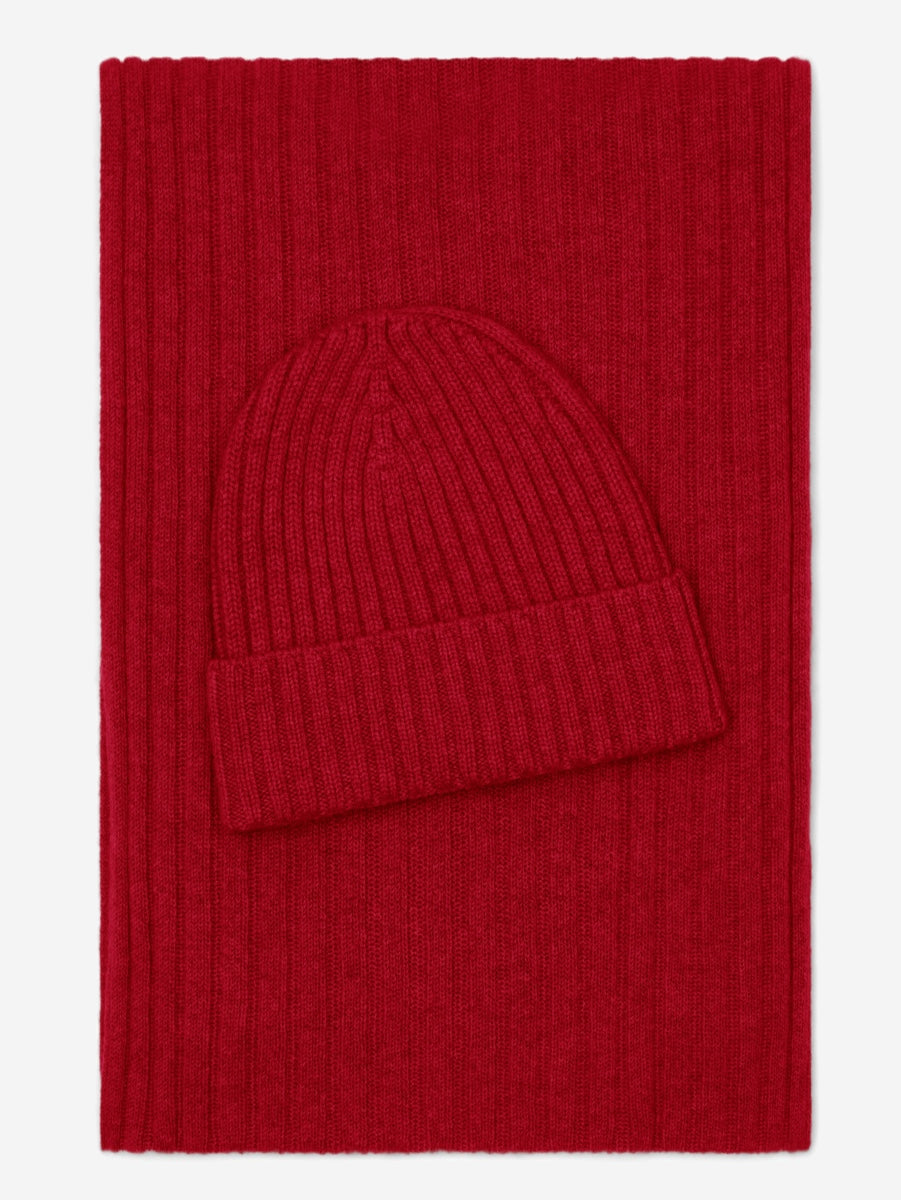 Red knit beanie and scarf set on a red background