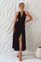 Woman wearing a black soft rayon maxi dress with halter neckline, smocked back, and fitted bodice, on a white background, front view 