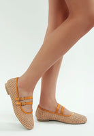 Woman wearing tan Double Strap Ballet Flats with woven texture and faux leather straps on a white background side view