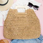 100% natural straw tote with wooden handles, top zipper closure, and a small sidewall pocket in khaki