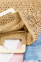 100% natural straw tote with wooden handles, top zipper closure, and a small sidewall pocket in khaki handle view