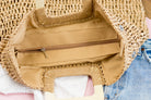 100% natural straw tote with wooden handles, top zipper closure, and a small sidewall pocket in khaki zipper view