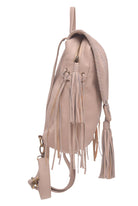 A light beige leather backpack with fringe details, braided straps, and a matching wristlet strap, shown from a side profile view on a white background.