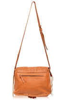 A tan leather crossbody bag with a long shoulder strap, featuring a woven pattern across the top flap, a front zippered pocket, and tassel details, shown against a plain white background, back view.