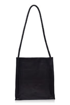A black leather tote bag with a long, thick braided shoulder strap, shown against a plain white background.