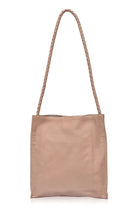 Beige leather tote bag with a rope handle on a white background
