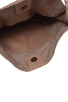 Close-up of interior of beige leather bag with visible stitching and hardware.