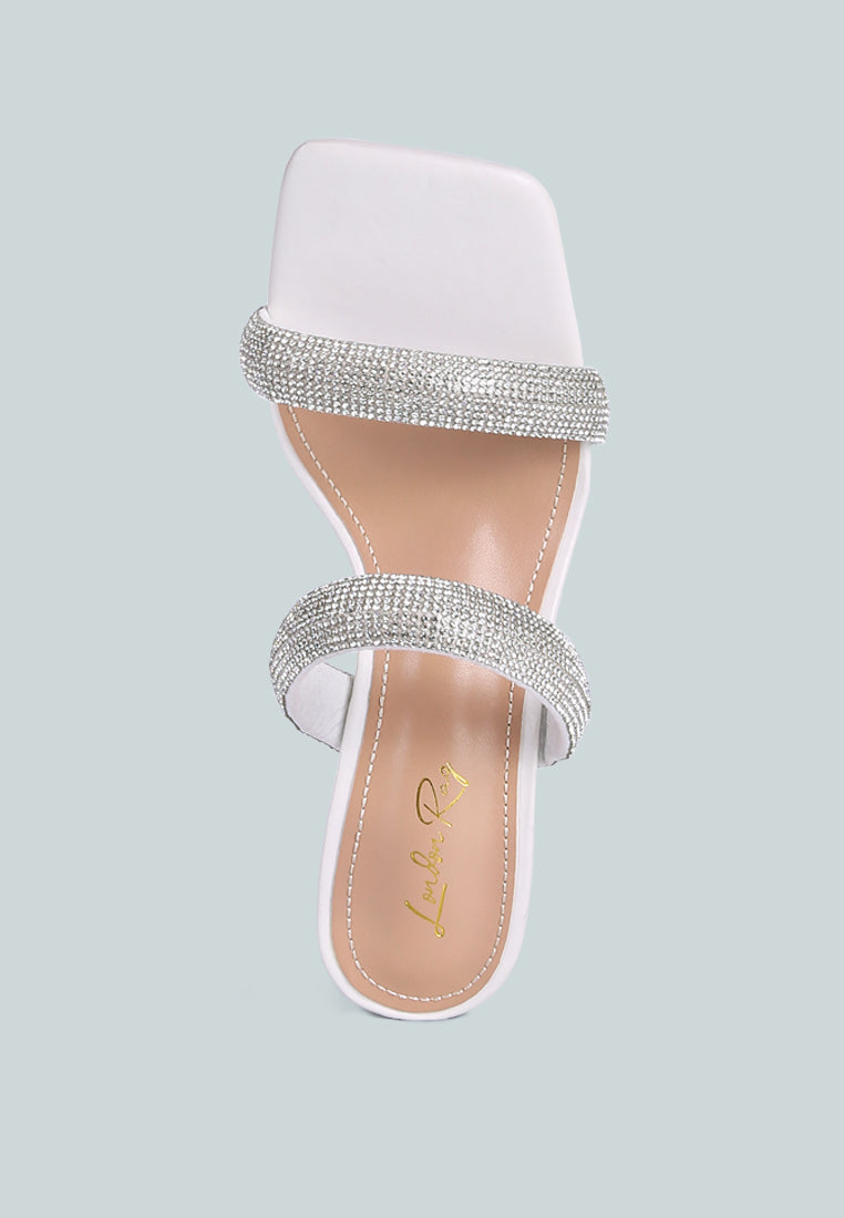 White high-heeled sandal with metallic heel, rhinestone details, and square toe on a white background, top view