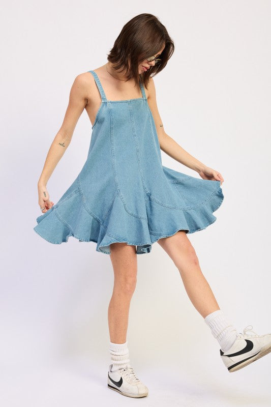 Woman wearing a light blue denim dress against a white background, front view