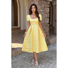 Model wearing yellow jacquard puff sleeve midi dress with square neckline and full skirt.
