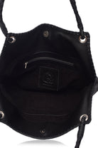 Closeup of suede lined interior of black leather handbag with visible brand logo on a white background