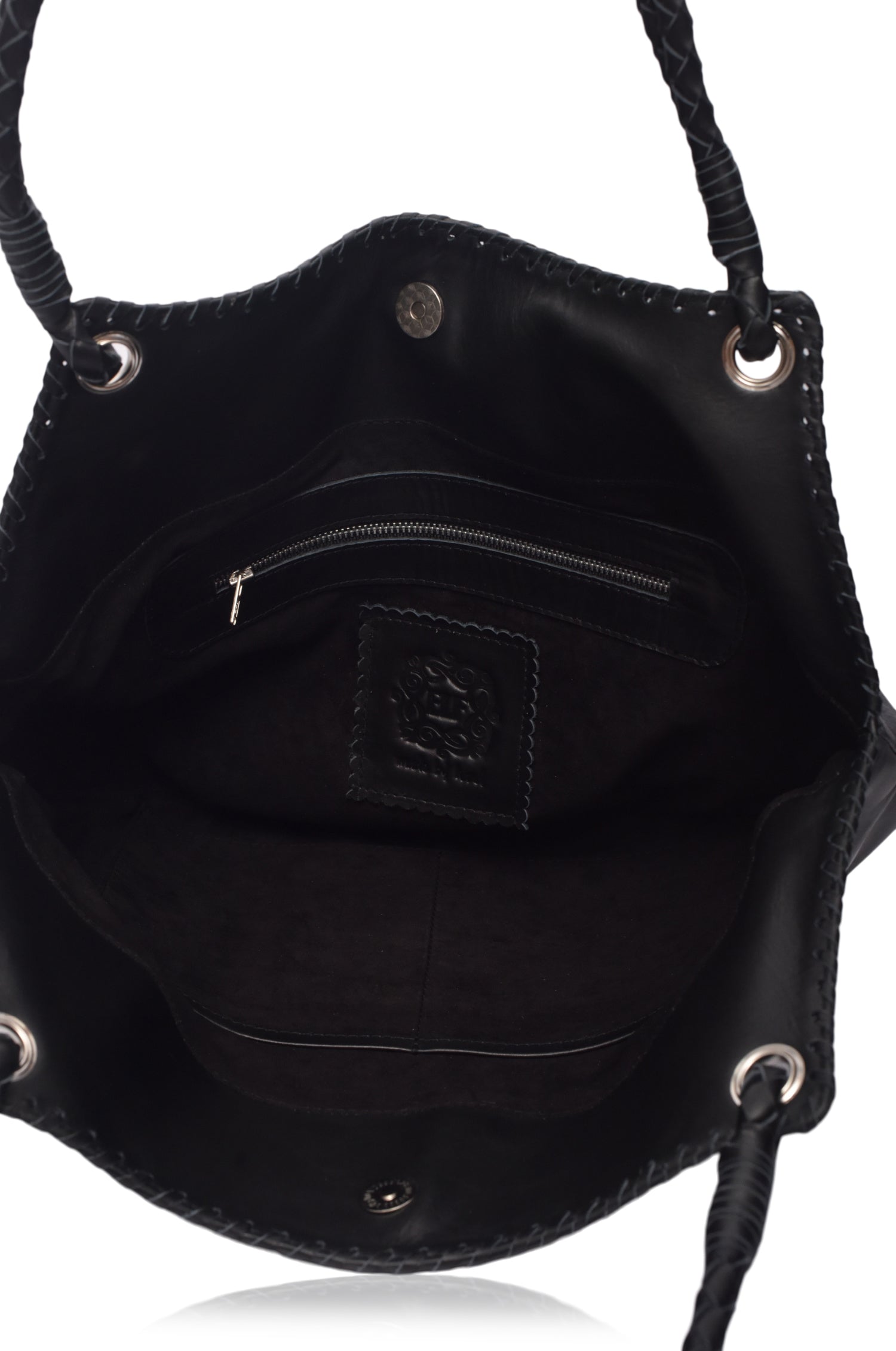 Closeup of suede lined interior of black leather handbag with visible brand logo on a white background