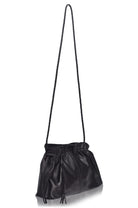 Black leather handbag with a long strap on a white background