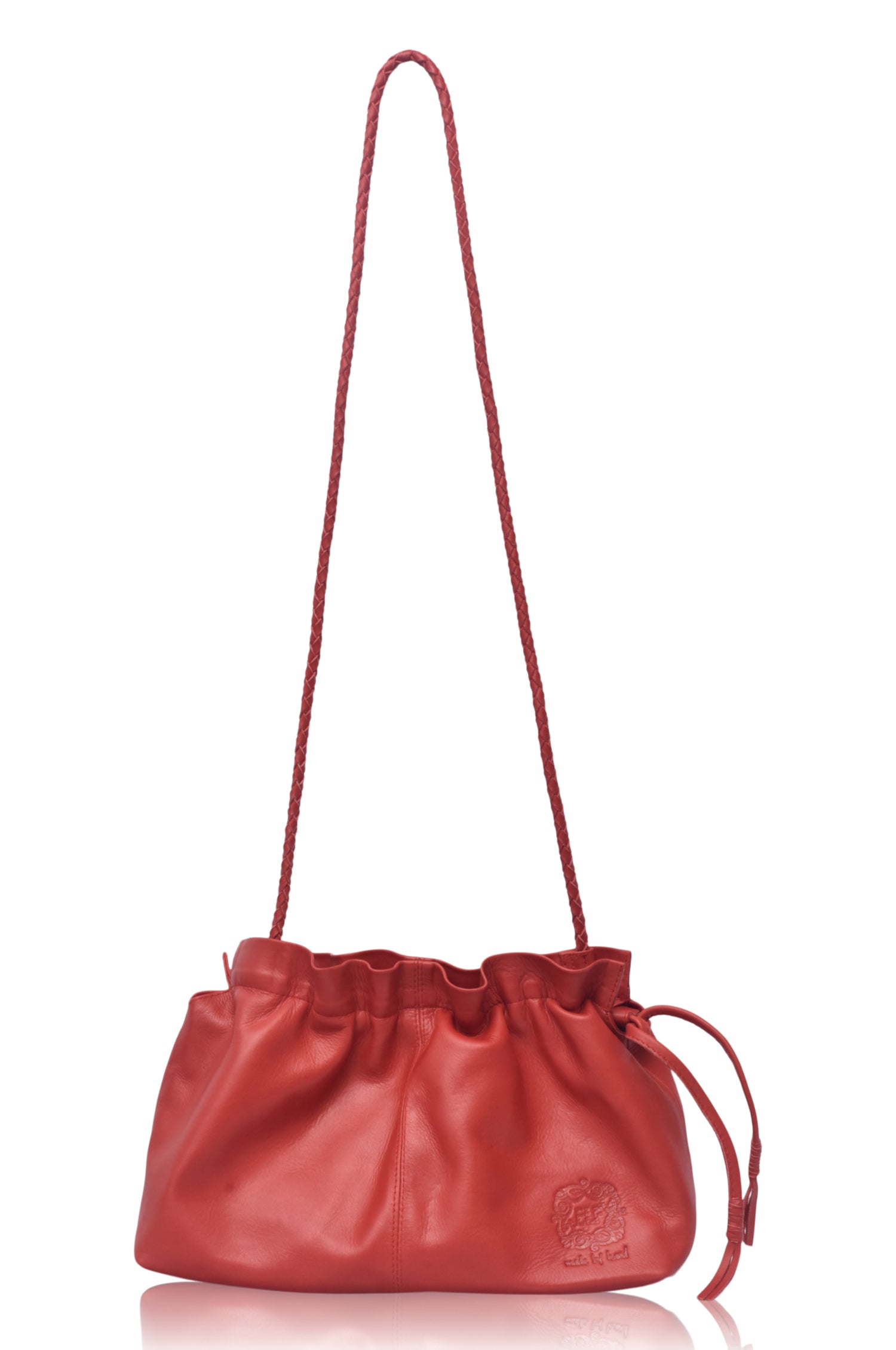 Red leather crossbody handbag with drawstring top and braided strap on a white background