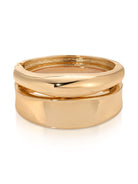 Two polished gold-tone hinged bangles stacked together on white background.