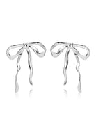 Silver-tone sculpted bow earrings with long ribbon tails on white background.
