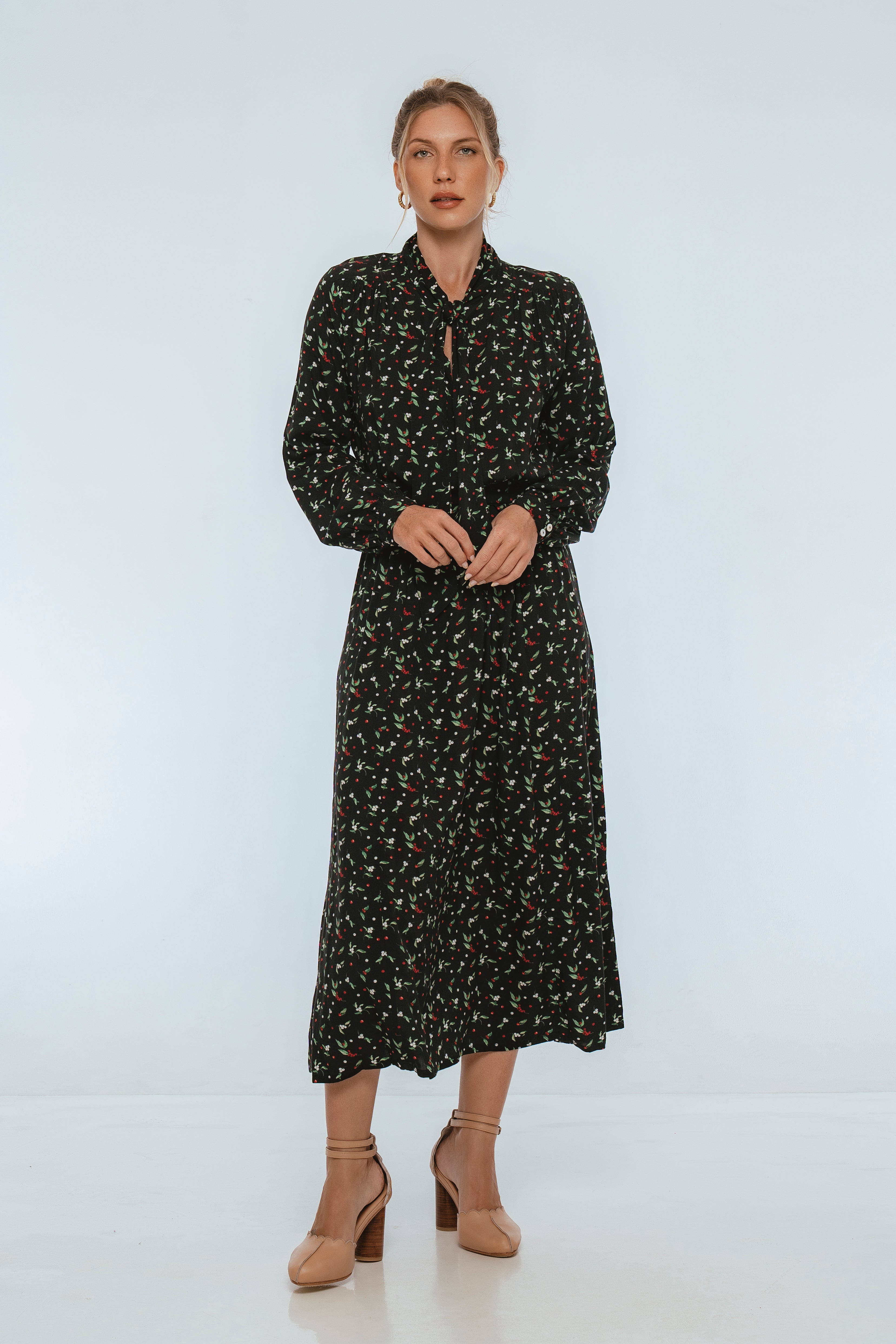 Woman wearing a black floral midi dress on a white background